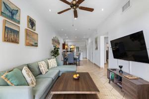 a living room with a couch and a tv at Oceanview Condo Across From Beach with Resort Pool in Tamarindo