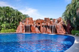 a waterfall in a pool at a resort at Oceanview Condo Across From Beach with Resort Pool in Tamarindo