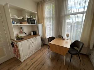a kitchen with a table and chairs and a window at B&B Muntzicht in Utrecht