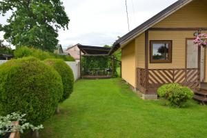 a backyard with a house and a yard with bushes at Jaani Puhkemaja in Pärnu