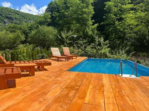 a wooden deck with benches and a swimming pool at Vikendica Raj in Bihać