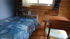 a bedroom with a bed and a wooden table and bench at こや・かやき in Yufu