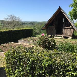 a garden with a small house and some bushes at La Maison Forte in Courtenay +9 photos