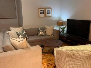 a living room with a couch and a flat screen tv at The Orchard in Hilton