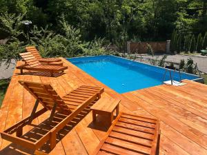 a wooden deck with a swimming pool and two chairs at Vikendica Raj in Bihać +16 photos