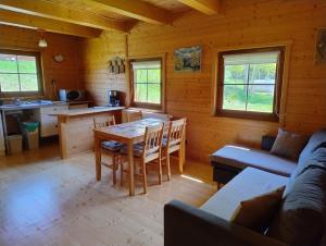 a kitchen and living room with a table and a couch at Chatka w gorach in Lewin Kłodzki
