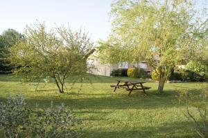a picnic table in the middle of a field with trees at Gite chez kinou in Montans