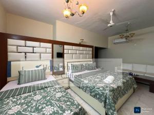 a bedroom with two beds and a sink at Hotel White Palace Clifton in Karachi