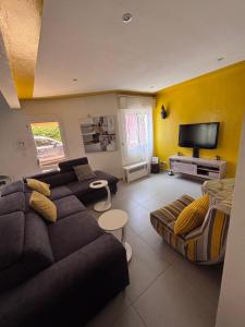 a living room with a couch and a tv at Residence Mangrove Saly in Ngaparou