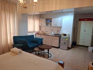 a room with a bed and a kitchen with a couch at Executive Express Rooftop Pool suites- Ngara in Nairobi