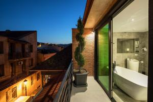 a bathroom with a bath tub and a window at Mit Hotel Tbilisi in Tbilisi City