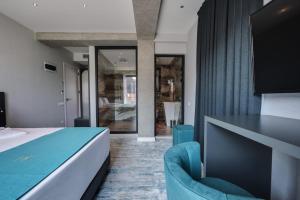 a bedroom with a bed and a blue chair at Mit Hotel Tbilisi in Tbilisi City