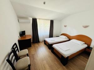 a room with two beds and a table and chairs at Pensiunea Delia Timișoara in Timişoara