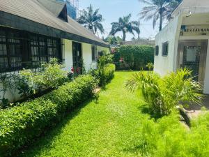 a yard next to a building with green grass and plants at Chambres d'hôtes WAIMEA in Abidjan