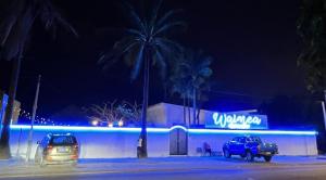 a building with cars parked in a parking lot at night at Chambres d'hôtes WAIMEA in Abidjan