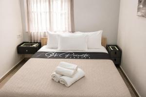 a bedroom with a bed with towels on it at 9-4 Private Houses in Kos
