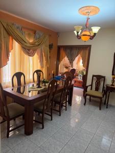 a dining room with a wooden table and chairs at Mary Vilaseca in SJM