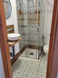 a bathroom with a shower and a sink and a toilet at Hostal Blanc Lloret in Lloret de Mar