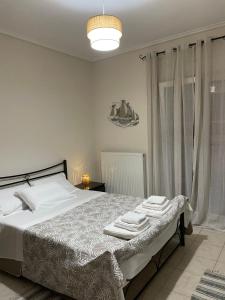 a bedroom with a bed with towels on it at Sea And Sand Apartment in Nea Kallikrateia