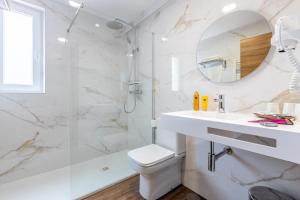 a white bathroom with a toilet and a shower at Hotel La Terraza in Miño +122 photos
