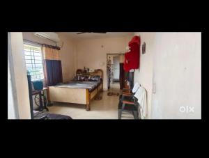 a bedroom with a bed and a chair in it at OM Tower in Jamshedpur