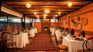 a row of tables in a room with white table cloth at Riad Medina Art & Suites in Marrakesh
