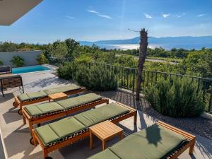 a patio with lounge chairs and a view of the ocean at VILLA MARIS SMRIKA -heated pool in Šmrika