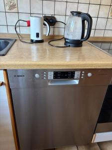 a kitchen counter with a appliance on top of a dishwasher at Sylbacher Gästehaus in Bad Salzuflen