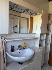 a bathroom with a white sink and a mirror at Sylbacher Gästehaus in Bad Salzuflen +34 photos