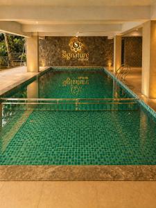 a swimming pool in a hotel with green tiles at The Signature Munnar in Munnar