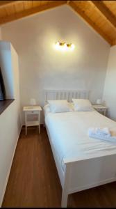 a white bedroom with a white bed and a table at VV Casa Los Brezos "by AFCVacacional" in Breña Alta