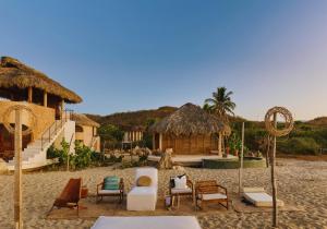 a group of chairs and tables on a beach at Casa Sal by Tasman in Puerto Escondido