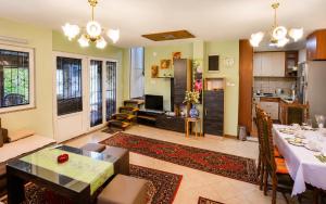 a living room with a table and a kitchen at Villa Indigo in Berovo