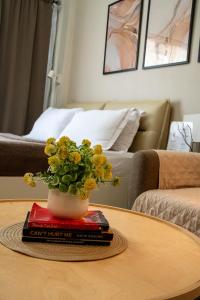 a table with a vase on top of a book at Crosswinds Tagaytay Holiday Home by KTCH in Tagaytay