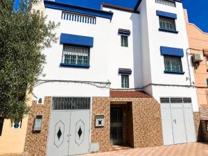 a white house with two garage doors at Melilla Gate House in Nador