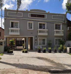 a large white building with potted plants in front of it at La Seven Dpto Turístico in Colón