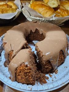 a piece of chocolate cake with chocolate icing on a plate at Pousada Bem Te Vi Lumiar in Lumiar