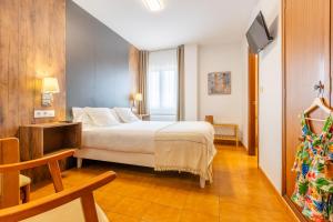 a hotel room with a bed and a tv at Hotel La Terraza in Miño