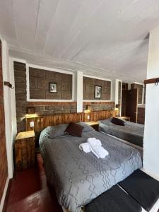 a bedroom with two beds with towels on them at La Misión Hotel Chignahuapan in Chignahuapan