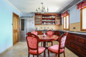 a kitchen with a table and chairs and a refrigerator at La Coraillère Waterfront Villa with Private Pool and Sea Access in Théoule-sur-Mer