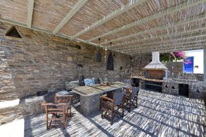 a patio with a table and chairs and a fireplace at Anastasia Home in Triandáros