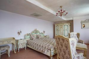 a bedroom with a bed and a desk and a chandelier at La Coraillère Waterfront Villa with Private Pool and Sea Access in Théoule-sur-Mer +106 photos