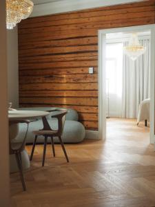 a dining room with a table and a wooden wall at Sugar Factory Apartments in Kotka