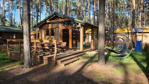 a wooden cabin in the woods with a picnic table at LAZY DAYS domek nr 26 w Borsku in Borsk