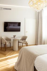 a bedroom with a bed and a table and chairs at Sugar Factory Apartments in Kotka +5 photos
