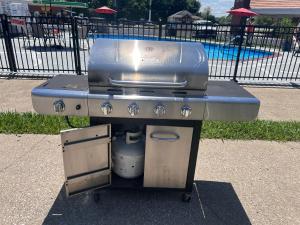 a grill sitting on a sidewalk next to a pool at 7 Gables Motel Burnside Near Somerset US 27 in Burnside