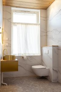 a bathroom with a sink and a toilet and a window at Sugar Factory Apartments in Kotka