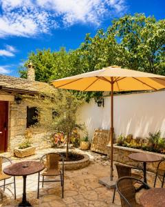 a patio with tables and an umbrella at Villa Fortuna in Mostar