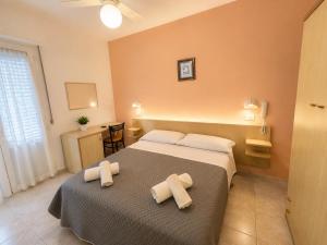 a bedroom with a bed with two towels on it at Hotel Malibù in Rimini