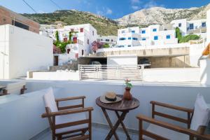 a table and chairs on a balcony with white buildings at To Steno in Kamares